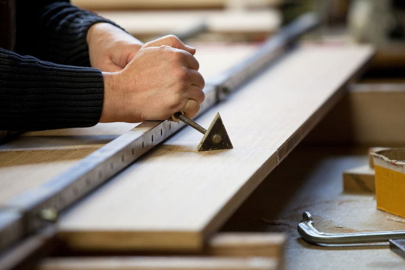 从木板上刮胶水。