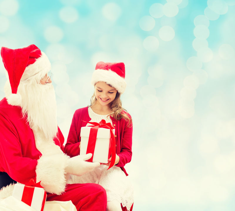 带着圣诞老人和礼物微笑的小女孩