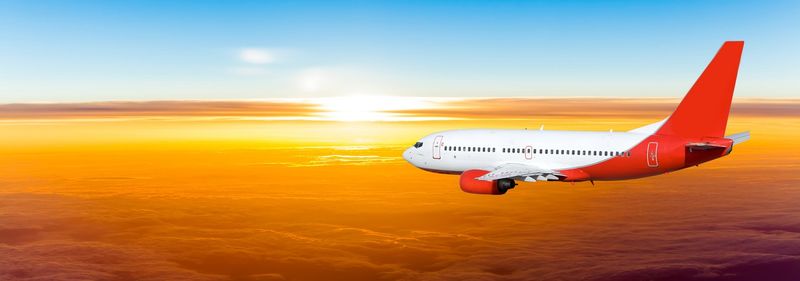 日落时天空中的飞机。天空中的客机