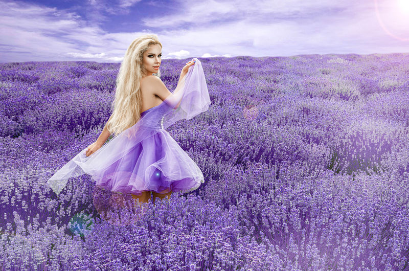 美丽的模特在春夏的薰衣草地里行走，在日出的时候。薰衣草田金发女孩-图片