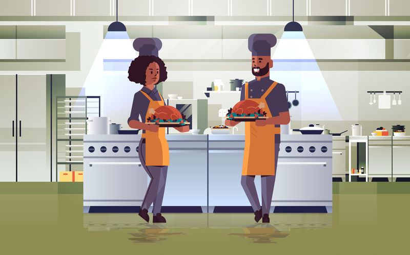 专业厨师夫妇端着托盘和烤鸡男女士身着制服，手持感恩节火鸡烹饪食品概念现代餐厅厨房内部全长水平