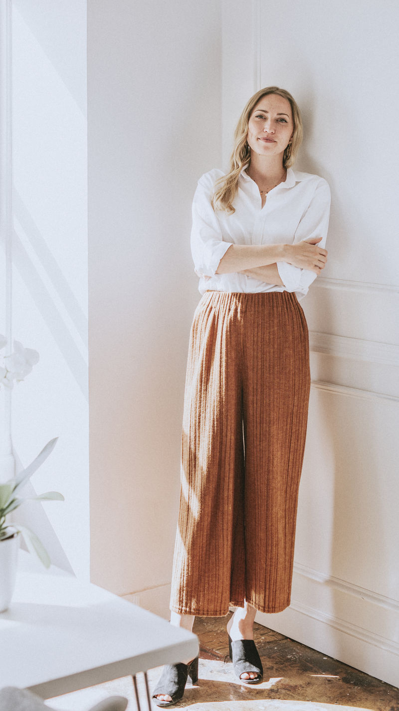 站在白墙上的时髦女人