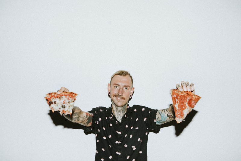 吃意大利香肠披萨的男人