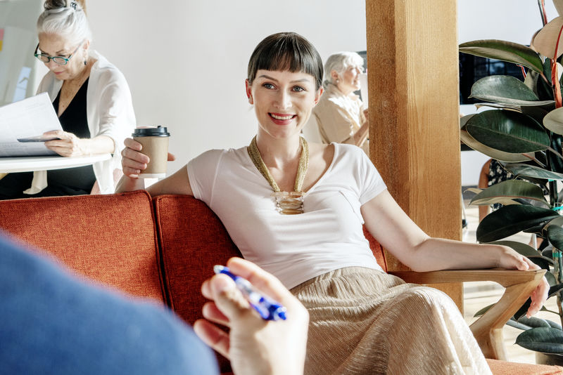 在会议上喝咖啡的开朗的女人