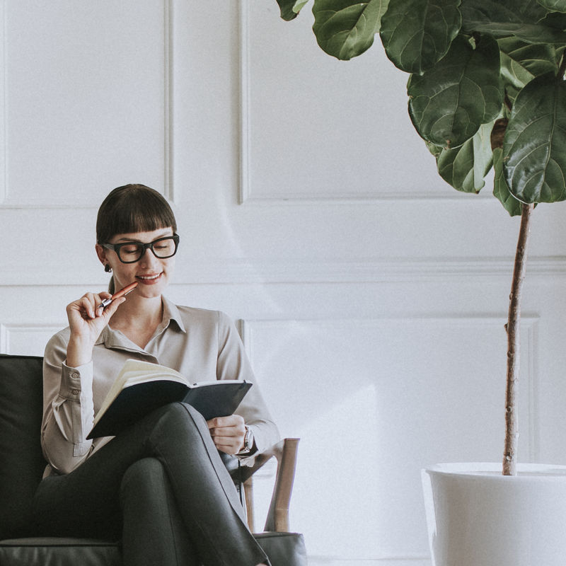 随意的年轻女人和她的计划者坐在沙发上
