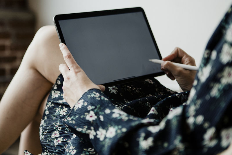 女性在数字平板电脑上写博客