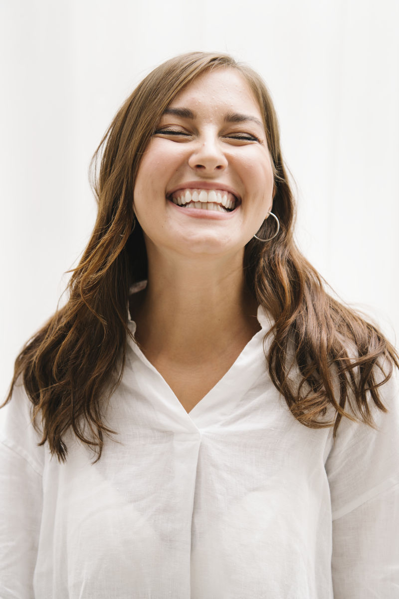 站在白色墙壁上的欢快的女人