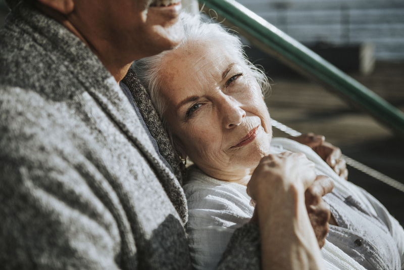 浪漫的老两口坐在码头上