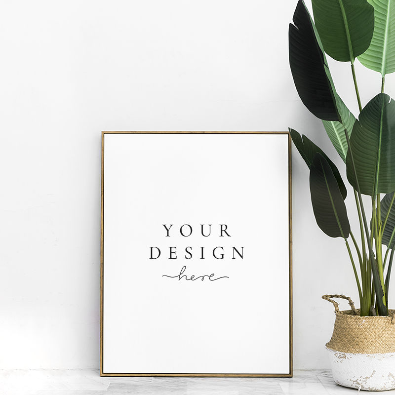 地板上室内植物旁的空白金色相框