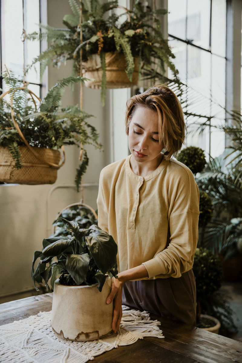 在温室里照料花草的女人