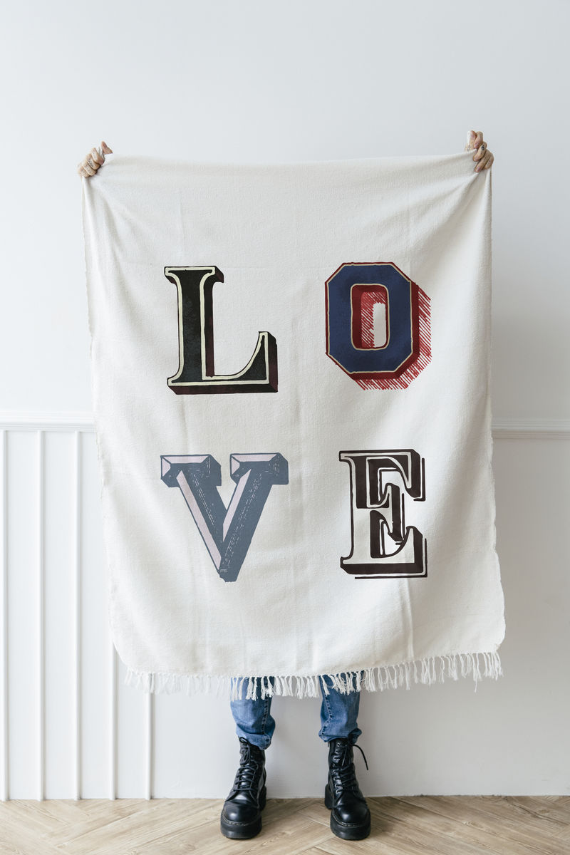 一个穿着黑色皮靴的女人展示着一张白色布料的海报