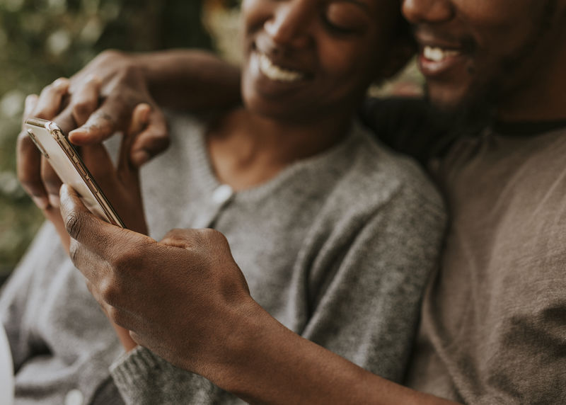 快乐的黑人夫妇用智能手机