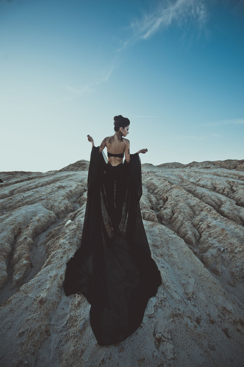 夕阳下在黑色织物的褶皱中的女孩