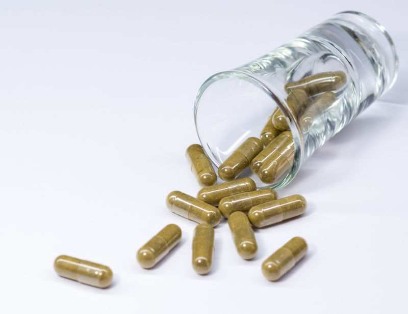 白色背景的胶囊和玻璃