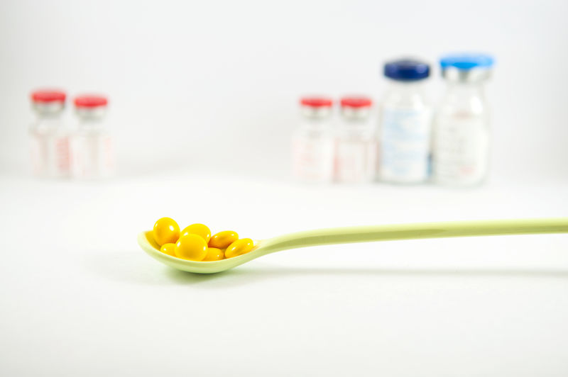 小瓶背景的汤匙黄色包衣片
