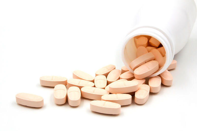 粉红色的药丸白色背景的药瓶