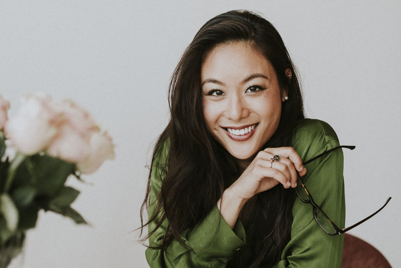 站在白墙旁的美丽欢快的女人