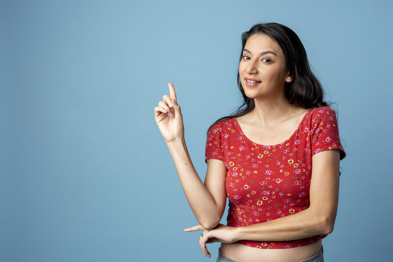 在蓝色背景下孤独的快乐的亚洲女人