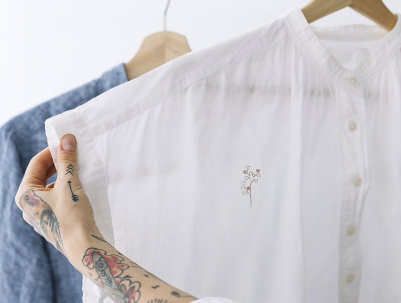 在架子上拿着一件白衬衫模型的女人