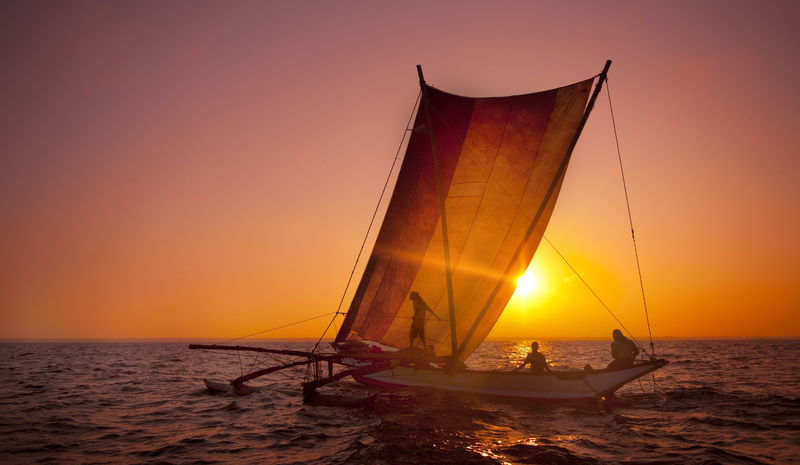日落时双体船上的渔民