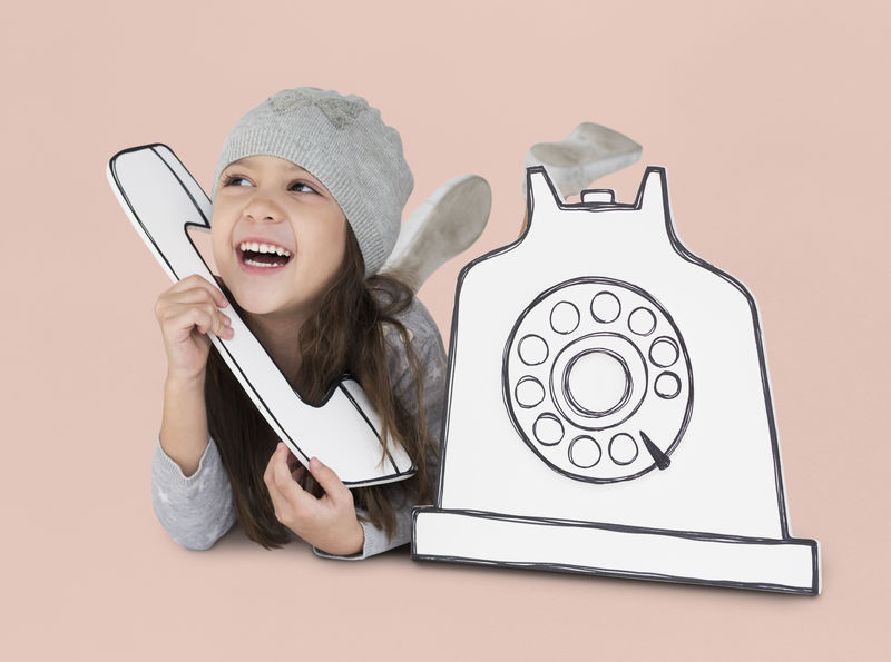 小女孩在玩纸手机