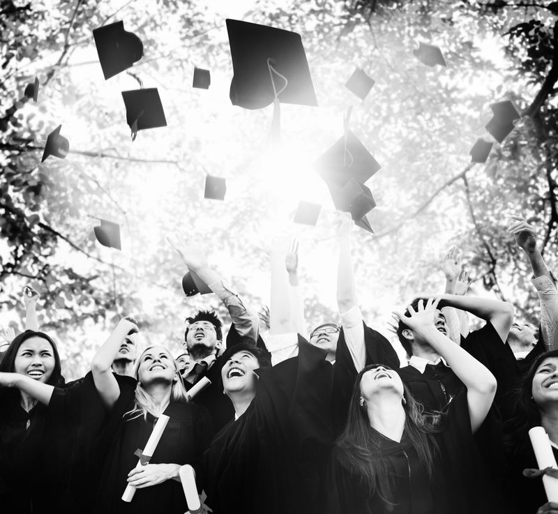 多样化的毕业生向空中扔帽子