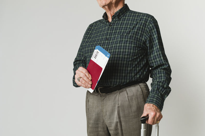 持机票和护照携带行李的高级男子旅客