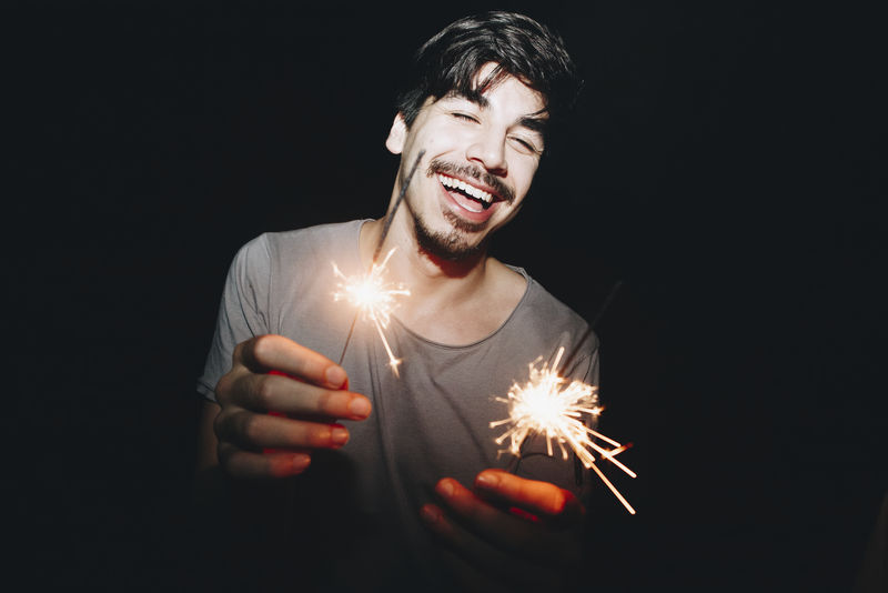 高加索男人玩火花庆祝和节日派对概念