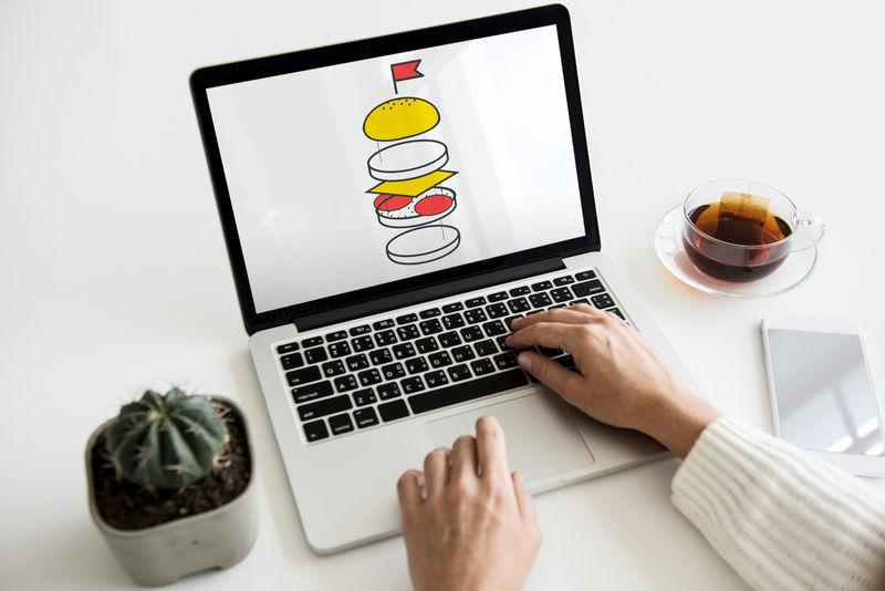 女性手在笔记本电脑上制作汉堡图案