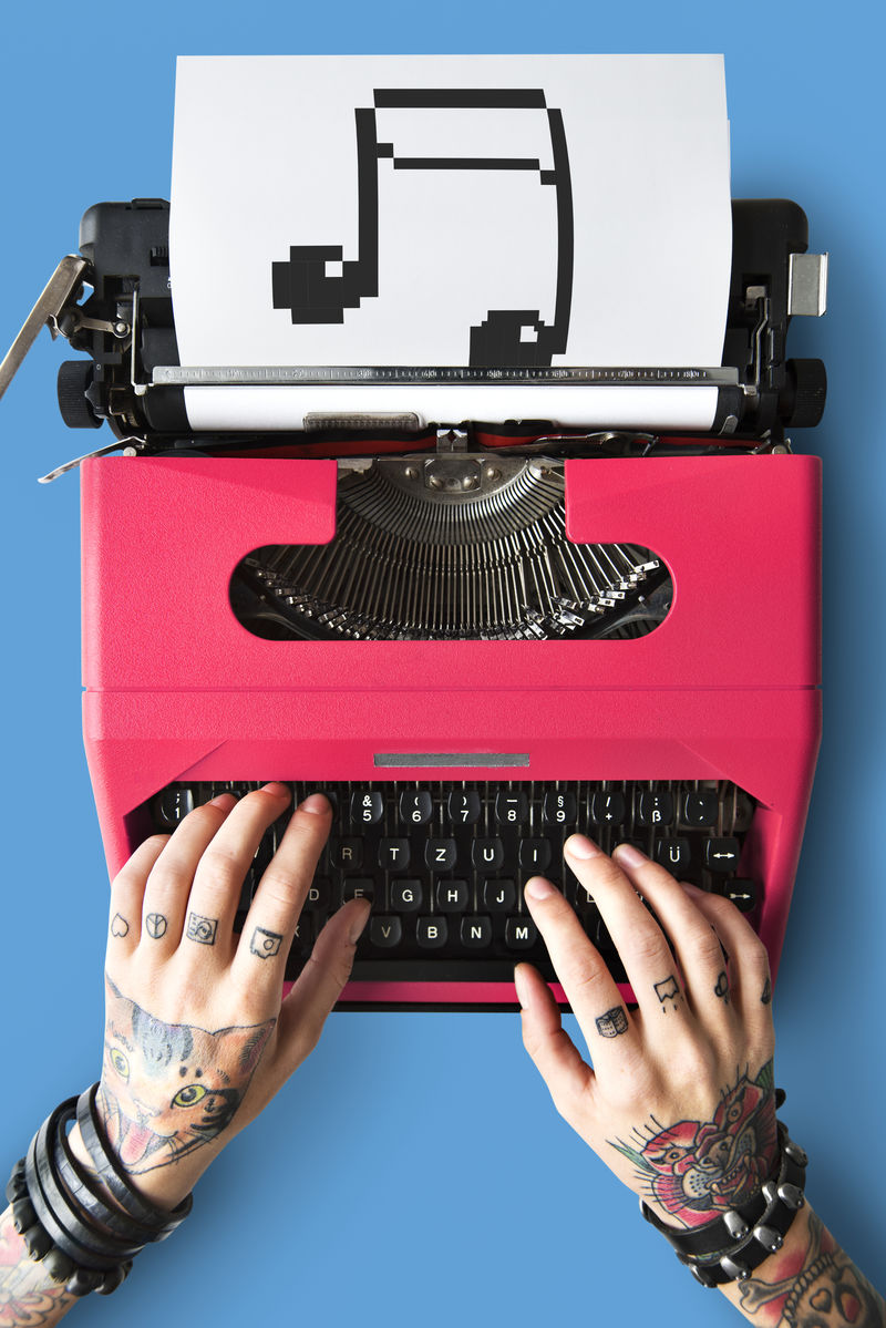 有纹身的女人在打字机上打字