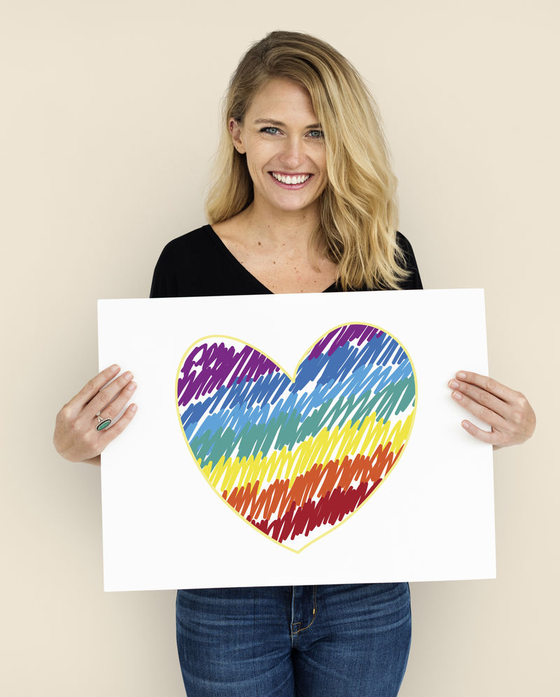 手持LGBT心形图标标语牌的女子