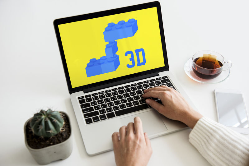 女性手在笔记本电脑上创建三维积木图形