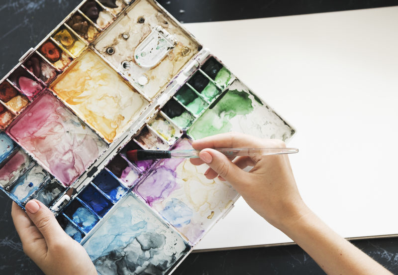 艺术家在桌子上画彩色插图文具