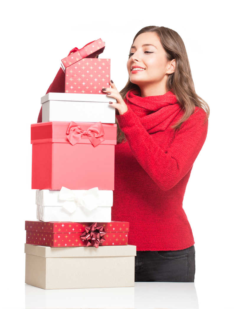 白色背景下的年轻美女在看圣诞礼物盒