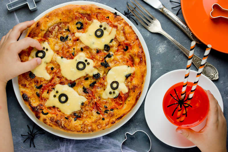 万圣节派对给孩子们吃奶酪和橄榄的比萨饼
