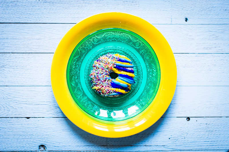 放在盘中的五颜六色油炸甜甜圈