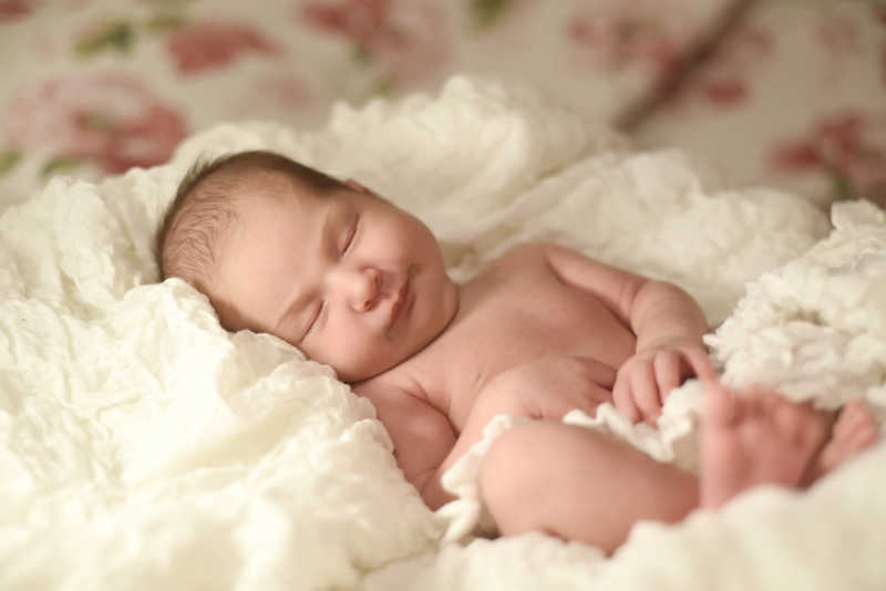 睡在白色毯子上的婴儿