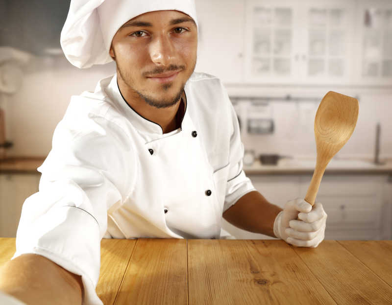 厨房里拿着木勺的厨师