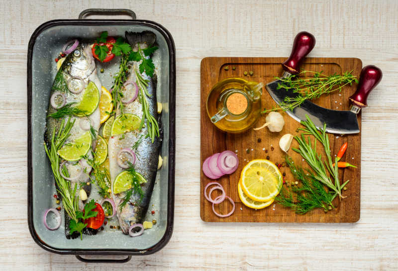 案板上的烹饪原料和锅中原料腌制的鱼