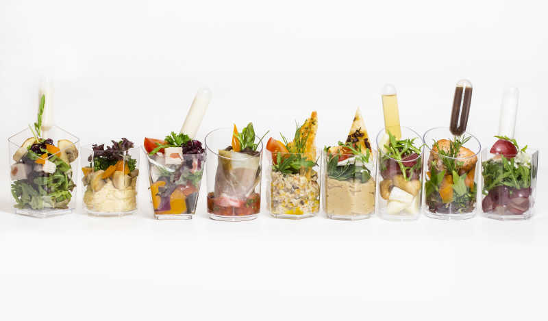 杯中带肉和蔬菜的不同的小型美食