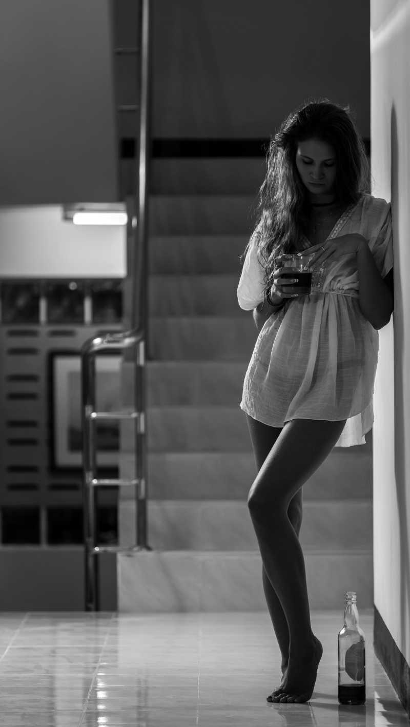 性感的忧郁女孩在孤独中饮酒