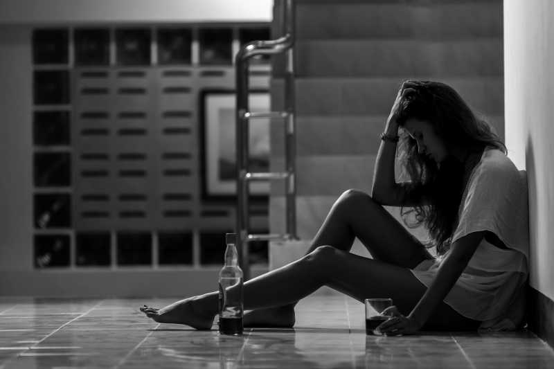 忧郁女孩在孤独中饮酒