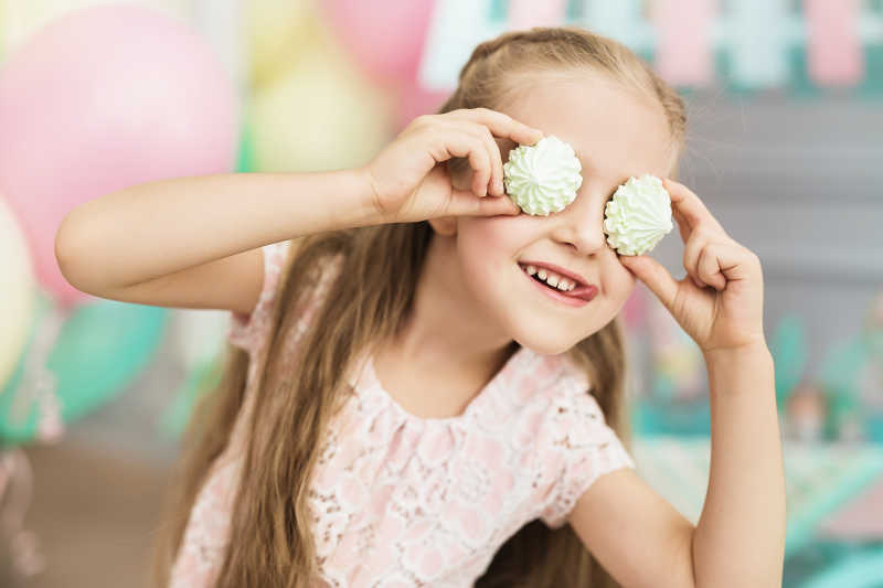 小女孩正在用蛋糕做鬼脸