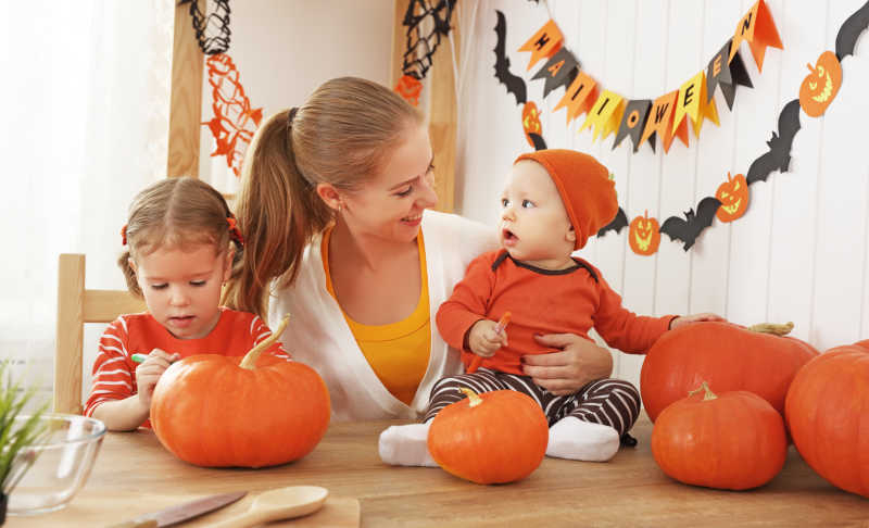 快乐的一家人准备万圣节的装饰过程中