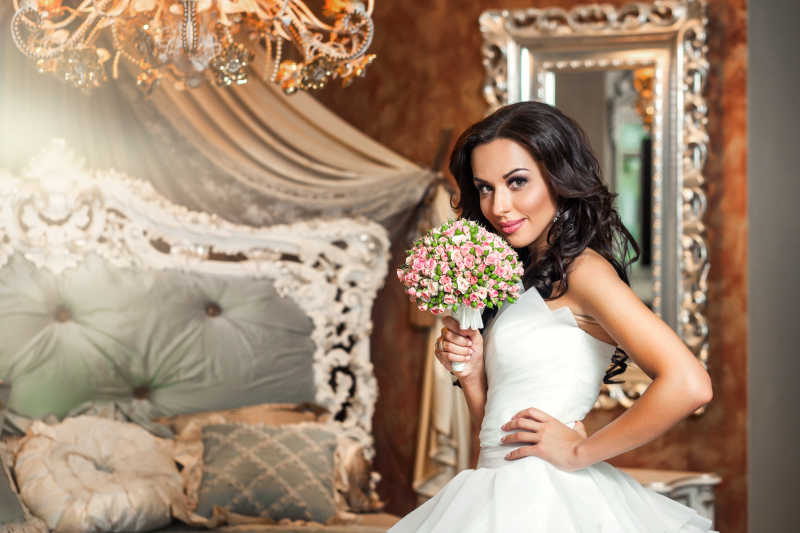 卧室里拿着鲜花的漂亮新娘