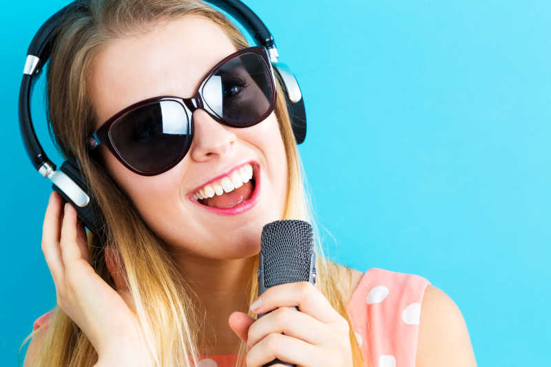 戴墨镜听音乐的金发美女