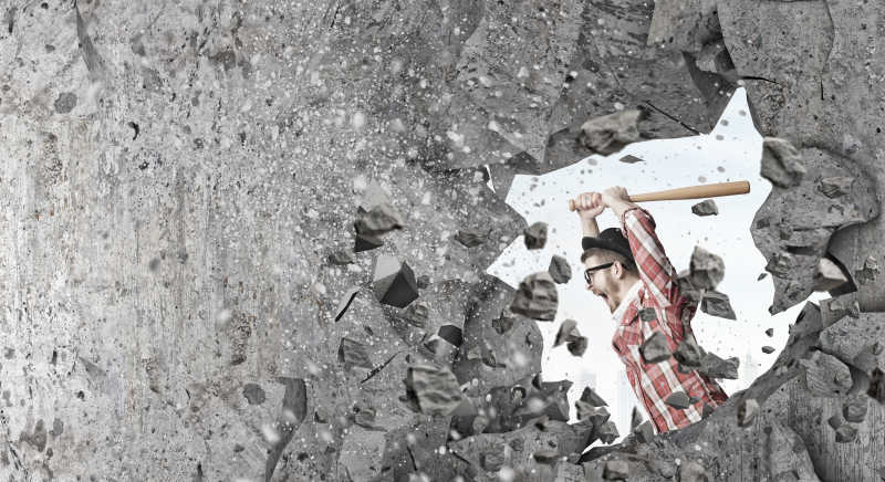 举起棒子愤怒砸墙的男人