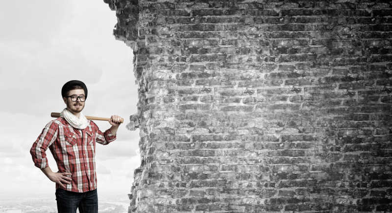 墙壁前拿着棒子的男人