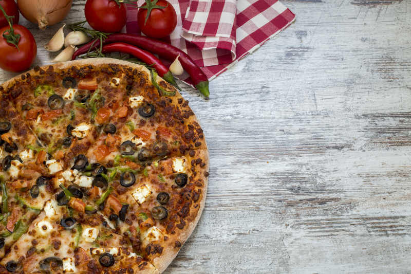 在厨房的木桌上的美味的意大利披萨饼