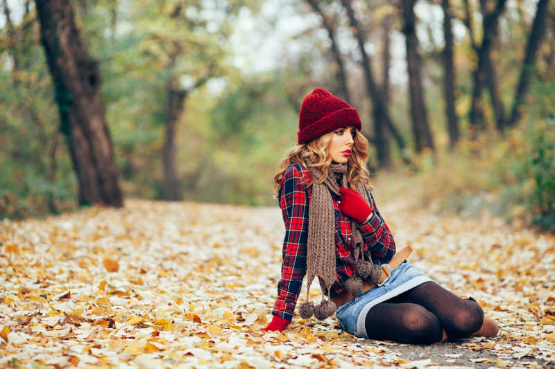 秋季时装美女在树林中的地上